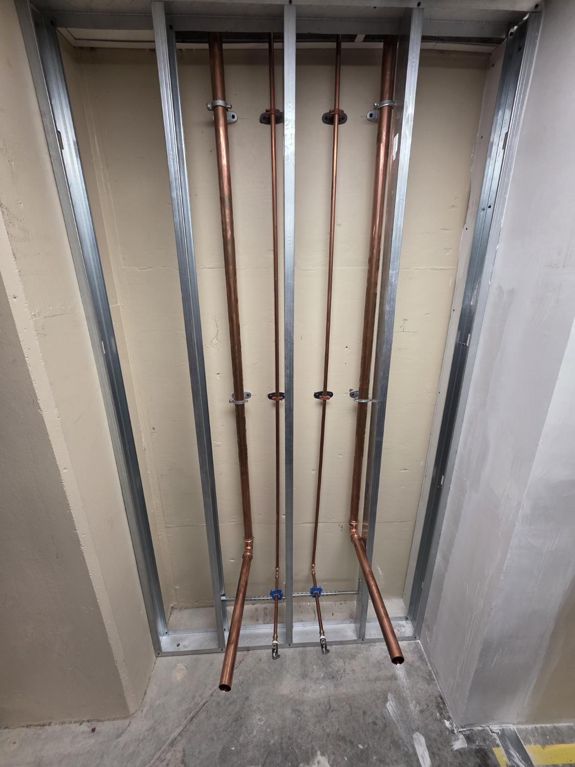 Copper lines roughed in on a metal stud wall